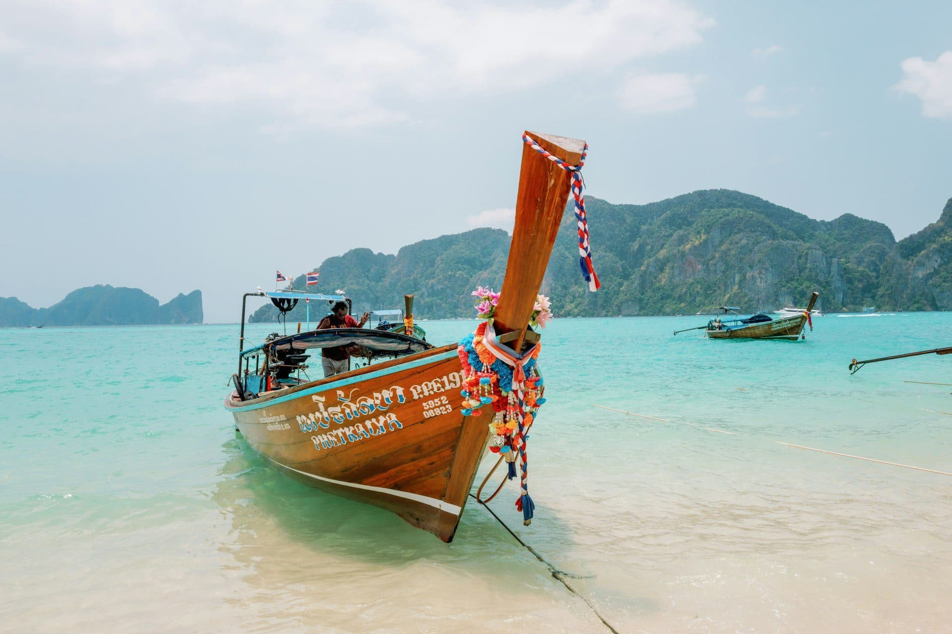 Thai longtail boat in bright turquoise water under a sunny sky — Phi Phi Islands, Thailand
